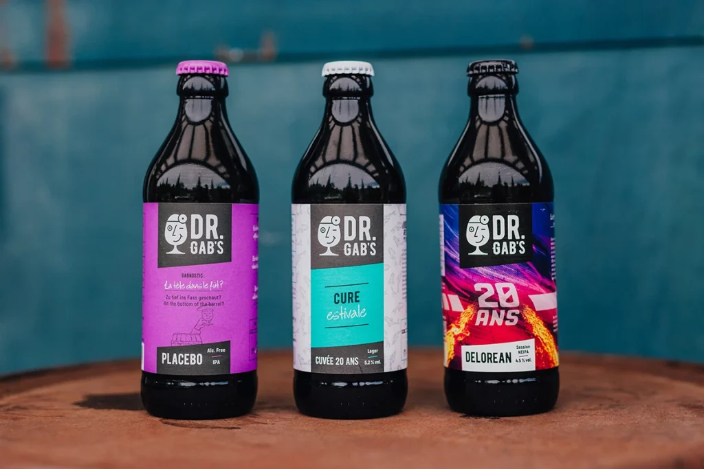Photographie de branding pour la brasserie Dr. Gab's par Speetch : packshot de trois bières artisanales (Placebo, Cure Estivale, DeLorean) pour une identité visuelle d'entreprise dans le Canton de Vaud.