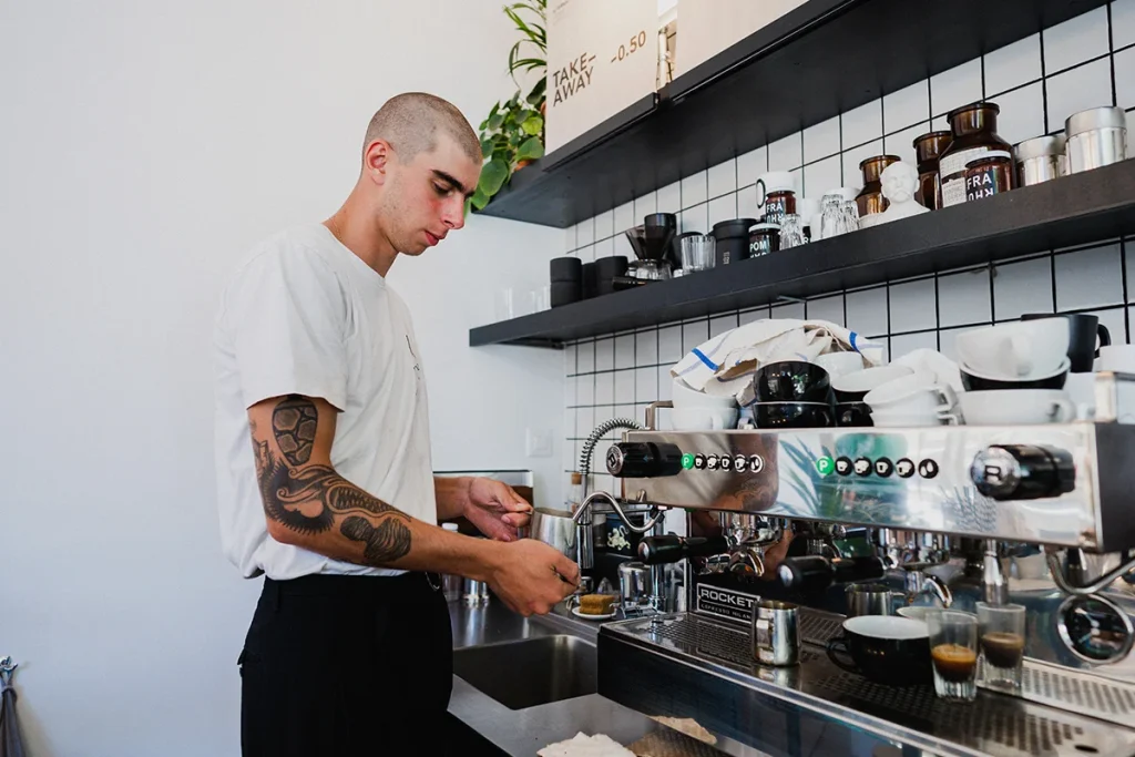 Photographie de reportage métier réalisée par Speetch au café Coffee Page à Lausanne : portrait d'un barista en action préparant un café de spécialité, illustration du savoir-faire en entreprise dans le Canton de Vaud.