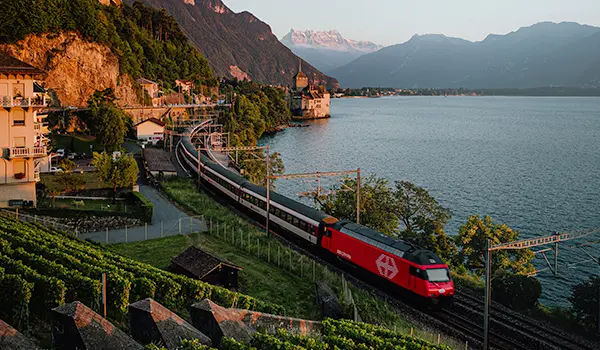 Photographie professionnelle par Speetch : train CFF longeant le Lac Léman avec le Château de Chillon en arrière-plan, Suisse romande.